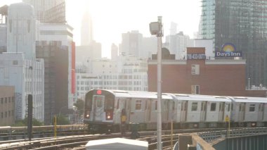 New York, ABD - 2 Eylül 2023 Metro İstasyonu. Metro treni toplu taşıma platformu. Yükseltilmiş dış demiryolu, Queens yolcu demiryolu trafiği, Long Island. Empire State Binası.