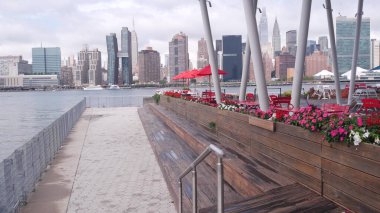 New York, Amerika Birleşik Devletleri - 30 Ağustos 2023 Waterfront Skyline, Manhattan Midtown binaları, East River 'daki nehir manzaralı gökdelenler. Liman kenti manzarası, Hunters Point rıhtım kolonları, Long Island, Queens.