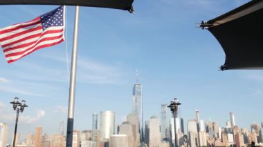 New York City rıhtımı, Manhattan şehir merkezi finans bölgesi, Dünya Ticaret Merkezi binası, nehir manzaralı gökdelenler. Amerikan bayrağı 11 Eylül anısına. New Jersey, ABD.