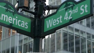 New York City kavşağı, 42 sokak kavşağı yeşil yol tabelası. 6. Cadde, Amerika Bulvarı, Midtown İş Bölgesi, New York, Bryant Park. Yükselen gökdelen mimarisi, metin yol işareti.