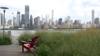 New York şehri kıyısı silueti, Manhattan şehir merkezi binaları, nehir kıyısındaki gökdelenler, doğu nehri suyu. Liman kenti manzarası, Gantry Plaza Park, Long Island, Queens. Birleşik Devletler. Koltuk sırası..