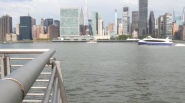 New York şehri kıyısı silueti, Manhattan şehir merkezi binaları, nehir kıyısındaki gökdelenler, doğu nehri suyu. Liman kenti manzarası, Gantry Plaza Park, Long Island, Queens. Birleşik Devletler mimarisi.