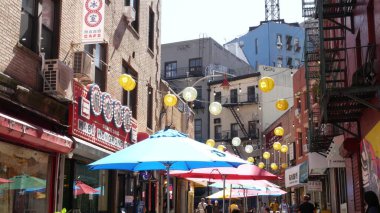 New York, ABD - 14 Eylül 2023: Manhattan Chinatown Doyers Caddesi, Çin etnik bölge mimarisi. İnsanlar, şenlikli kağıt fenerler, sokak yemeği şemsiyeleri. Su kulesi tankı.