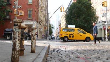 New York, ABD - 8 Eylül 2023: Manhattan Soho moda bölgesi Broadway caddesi yakınlarında. Amerikan şehir binası cephesi, eski klasik Amerikan mimarisi. New York 'tan alışveriş. Millet, sarı taksi.