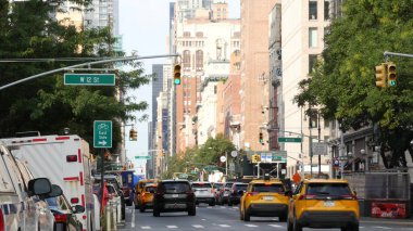 New York, ABD - 10 Eylül 2023 Manhattan Greenwich Village Caddesi, 6. Amerika Bulvarı kavşağı. ABD 'de şehir trafiği. İnsanlar, zebra, sarı taksi. Kırmızı tuğla binalar.