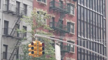 New York caddesi kavşağı, sarı trafik ışığı, ulaşım yolu kavşağı, Birleşik Devletler. Konut mimarisi. New York Emlak, yangın merdivenli kırmızı kahverengi tuğlalı ev. Manhattan.