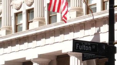 New York City kavşağı, Fulton sokak kavşağı tabelası. Manhattan şehir merkezi finans bölgesi mimarisi, NYC, ABD. Broadway yakınlarında Amerikan bayrağı ve yol tabelası.