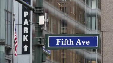 Beşinci cadde, 5 ave yolu tabelası, Manhattan şehir merkezi mimarisi, New York 5 av sokağı köşesi. Trafik kavşağı tabelası, ABD. Otopark ve Amerikan bayrağı.