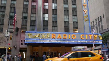 New York, ABD - 10 Eylül 2023 Manhattan Midtown Caddesi. Radio City Music Hall, Rockefeller Center, ABD. Yayalar, şehir trafiği, 6. Amerika Bulvarı kavşağı, sarı taksi..