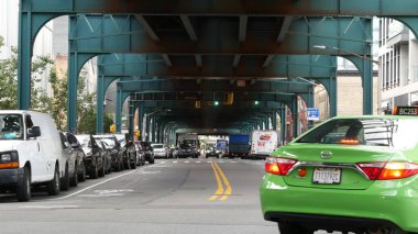 New York, Birleşik Devletler - 31 Ağustos 2023: sokağın üstündeki metro yükseltilmiş. Yolun üzerindeki Metropolitan Köprüsü, Queens. Long Island metro hattı, Court Meydanı. Metalik demiryolu altında arabalar. Yeşil taksi.
