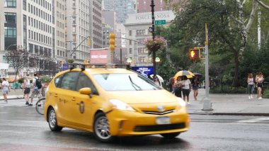 New York, ABD - 8 Eylül 2023 Manhattan Midtown Broadway, 23 sokak, 5 bulvar kavşağı. Flatiron Binası 'ndan Madison Square Park, ABD. İnsanlar, metro ve sarı taksi. Yağmur yağar.