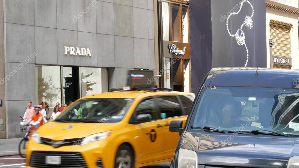 New York City, United States - 13 Sept 2023: Manhattan Midtown street, Fifth 5 avenue. American urban road car traffic. Yellow taxi cab in USA. People pedestrians. Boutique fashion stores for shopping