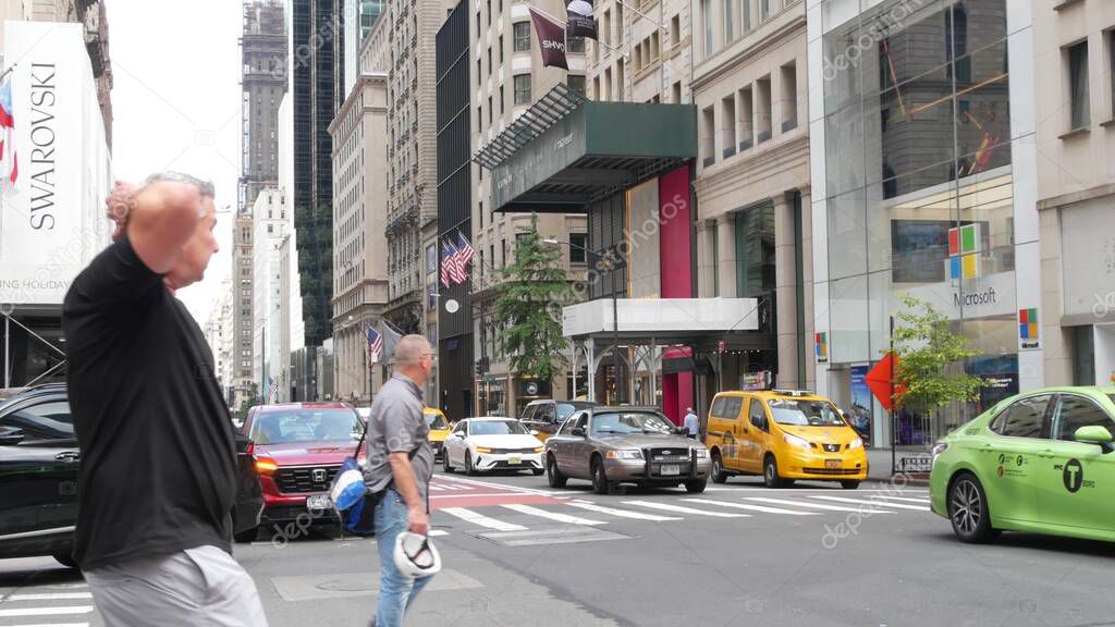 New York City, United States - 11 Sept 2023: Manhattan Midtown street, Fifth 5 avenue. American urban road car traffic. Yellow taxi cab in USA. People pedestrians. Boutique fashion stores for shopping