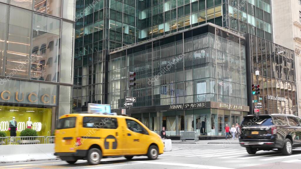 New York City, United States - 13 Sept 2023: Manhattan Midtown street, Fifth 5 avenue. American urban road car traffic. Yellow taxi in USA. People. Boutique fashion stores for shopping, Gucci, Armani.