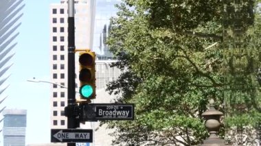 Broadway sokak tabelası, Manhattan şehir merkezi finans bölgesi mimarisi, New York, Fulton sokak köşesi. Trafik levhası. Dünya Ticaret Merkezi yakınlarında sarı trafik ışığı.