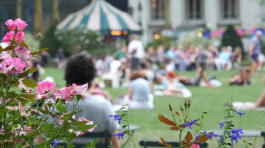 New York, ABD - 5 Eylül 2023: Manhattan şehir merkezi Bryant Parkı, 42 sokak ve 5. Cadde. ABD 'de NYC' de. Yaz yeşilliklerinde sandalye ve masa. Çimenlerdeki insanlar.