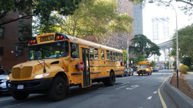 New York, Birleşik Devletler - 7 Eylül 2023: Sarı Okul Otobüsü, Manhattan Köprüsü, okul otobüsü kamyonu, şehir sokağı. Çocuk eğitimi ve Amerikan ulaşımı. Amerikan yerleşim bölgesi okul servisi.