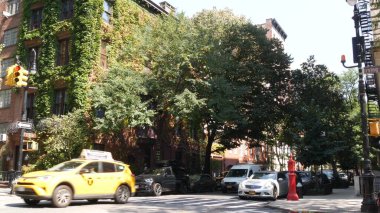 New York City, ABD, 6 Eylül 2023 Manhattan şehir merkezi Irving sokak köşesi, kavşak, Gramercy, ABD. İnsanlar yayalar. Sarı taksi. Sarmaşık yapraklarıyla kaplı kırmızı tuğladan ev