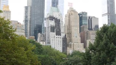 New York Şehri Manhattan Midtown. 5. Cadde 'deki Central Park, ABD. Amerika 'nın simgesi, NYC, ABD' deki şehir parkı. Gökdelen binaları mimarisi, 59 sokak silueti. Yeşil ağaçlar.