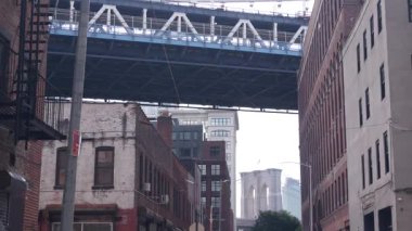 New York City Manhattan Köprüsü, Dumbo, Brooklyn Köprüsü. Brooklyn 'deki Plymouth caddesinde endüstriyel kırmızı tuğla binalar. Yangın merdivenli klasik NYC mimarisi. İki köprü turist manzaralı.