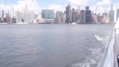 Feribottan New York City silueti. Manhattan şehir merkezinde, feribottan yükselen gökdelenler. Doğu nehri kıyısı manzarası, nehir kenarı mimarisi, ABD. Empire State, Chrysler Binası.