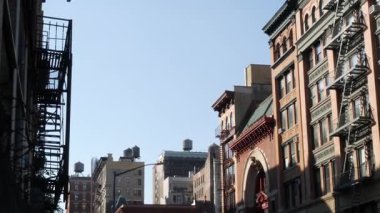 New York City Manhattan mimarisi. Şehir dışındaki konutlar. ABD 'de gayrimenkul. Kırmızı tuğla cephe. Yangın çıkışı, acil merdiven çıkışı. Çatıdaki su kulesi, çatıdaki tank..