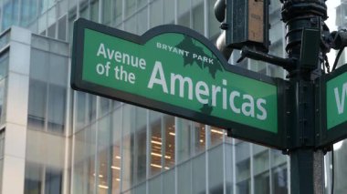 New York City kavşağı, sokak kavşağı yeşil yol tabelası. 6. Cadde, Amerika Bulvarı köşesi, Midtown İş Bölgesi, ABD. Yükselen gökdelen mimarisi, Bryant parkı metin yol işareti