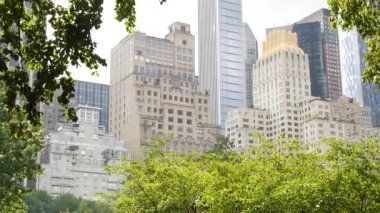 New York Şehri Manhattan Midtown. 5. Cadde 'deki Central Park, ABD. Amerika 'nın simgesi, NYC, ABD' deki şehir parkı. 59 caddedeki bahçe ağaçlarının oradaki bina mimarisi..