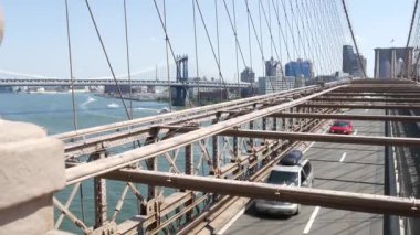 Brooklyn Köprüsü 'nde arabalar, New York City Manhattan Köprüsü manzaralı. Sarı taksi, trafik ve mimari. East River 'ın ikonik simgesi. ABD 'ye Seyahat.