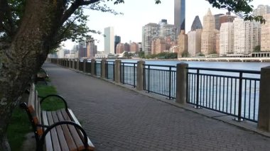 New York şehri kıyısı silueti, Manhattan şehir merkezi binaları, nehir kıyısındaki gökdelenler, doğu nehri suyu. Roosevelt Adası 'ndan deniz kenarı manzarası. Birleşik Devletler mimarisi ve gayrimenkul.