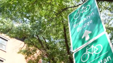Bisiklet şeridi tabelası, Brooklyn Heights sokağı, New York. Manhattan Köprüsü bisiklet yolu, bisiklet yolu. Bisikletçiler yeşil yol işareti, ağaçlar. Eğlence amaçlı spor faaliyeti altyapısı, Birleşik Devletler.