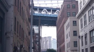 New York City Manhattan Köprüsü, Dumbo, Brooklyn Köprüsü. Brooklyn 'deki Plymouth caddesinde endüstriyel kırmızı tuğla binalar. Yangın merdivenli klasik NYC mimarisi. İki köprü turist manzaralı.
