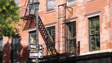New York City klasik bina mimarisi, Manhattan, ABD. Şehir dışındaki konutlar. Birleşik Devletler 'de gayrimenkul. Tipik kırmızı tuğla cephesi. Yangın merdiveni. Tek yönlü ok işareti.