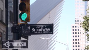 Broadway caddesi tabelası, Manhattan şehir merkezi finans bölgesi mimarisi. New York City, Fulton caddesi köşe tabelası. Dünya Ticaret Merkezi yakınlarında sarı trafik ışığı. Metro girişi. Tek yönlü ok