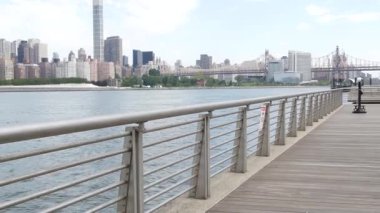 New York City rıhtım silueti, Manhattan Midtown binaları, nehir kenarındaki gökdelenler, Doğu nehri. Gantry Plaza Park, Long Island, Queens, ABD 'den deniz kenarı manzarası. Queensboro Köprüsü.