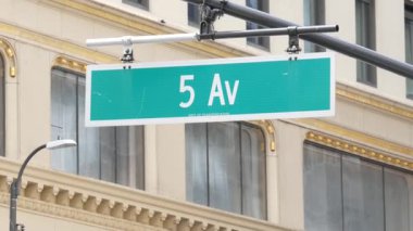 5. Cadde tabelası, Manhattan şehir merkezi mimarisi, New York 5. av sokağı köşesi. Yeşil trafik kavşağı tabelası, ABD. Sarı binanın penceresi.