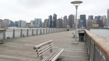 New York şehri kıyısı silueti, Manhattan şehir merkezi binaları, nehir kıyısındaki gökdelenler, doğu nehri suyu. Liman kenti manzarası, Gantry Plaza iskelesi, Long Island, Queens. Birleşik Devletler mimarisi.