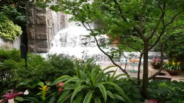 New York şehri hayatı, şehir parkı, Greenacre Park şelalesi. Amerikan Manhattan Midtown, ABD. Çiçek tarlasında tropikal çiçekler, ağaçlar yeşillik. NYC 51. Cadde 'deki yeşil vaha..