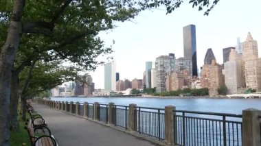 New York şehri kıyısı silueti, Manhattan şehir merkezi binaları, nehir kıyısındaki gökdelenler, doğu nehri suyu. Roosevelt Adası 'ndan deniz kenarı manzarası. Birleşik Devletler mimarisi ve gayrimenkul.