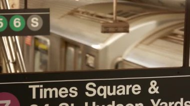 New York metro istasyonu içi, yeraltı metro platformu. Birleşik Devletler metro taşımacılığı. Demiryolu merkezi, yolcu trafiği kavşağı. Yazılı mesaj: Times Meydanı, Hudson Yards. Tren.