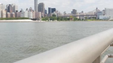 New York City rıhtım silueti, Manhattan Midtown binaları, nehir kenarındaki gökdelenler, Doğu nehri. Gantry Plaza Park, Long Island, Queens, ABD 'den deniz kenarı manzarası. Queensboro Köprüsü.