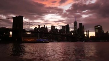 Brooklyn Köprüsü, New York City Manhattan şehir merkezi silueti, finans bölgesi şehir manzarası. Birleşik Devletler Dünya Ticaret Merkezi gökdeleni. Waterfront Pebble Sahili, Dumbo, ABD. Dramatik alacakaranlık bulutlu gökyüzü.