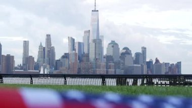 New York City rıhtım silueti, Manhattan Şehir Merkezi Dünya Ticaret Merkezi gökdeleni. New Jersey, ABD 'den şehir manzarası. Amerikan bayrağı 11 Eylül, ABD. Bağımsızlık ve Hatıra sembolü. Rüzgâr