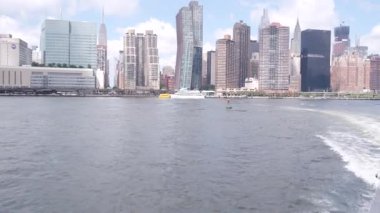 Feribottan New York City silueti. Manhattan şehir merkezinde, feribottan yükselen gökdelenler. Doğu nehri kıyısı manzarası, nehir kenarı mimarisi, ABD. Empire State, Chrysler Binası.