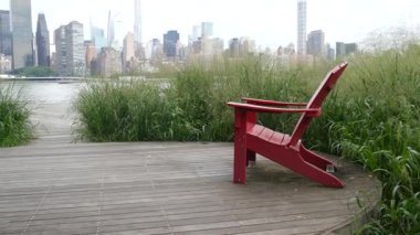 New York şehri kıyısı silueti, Manhattan şehir merkezi binaları, nehir kıyısındaki gökdelenler, doğu nehri suyu. Liman kenti manzarası, Gantry Plaza Park, Long Island, Queens. Birleşik Devletler. Koltuk sırası..