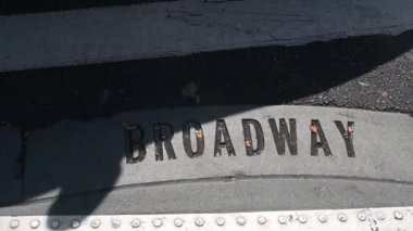 Broadway sokak tabelası, yaya zebra kavşağındaki insanlar. New York City Manhattan kavşağı. Yaya geçidinde asfalt, kavşaktaki gölgeler. Trafik levhası, Birleşik Devletler