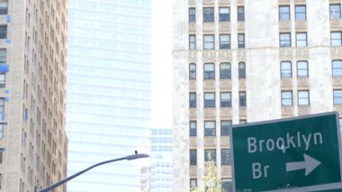 New York, Brooklyn Köprüsü yol tabelası. Manhattan şehir merkezi finans bölgesi mimarisi, NYC Birleşik Devletleri. Yeşil metin yol işareti ve ok