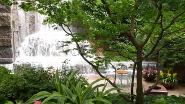 New York şehri hayatı, şehir parkı, Greenacre Park şelalesi. Amerikan Manhattan Midtown, ABD. Çiçek tarlasında tropikal çiçekler, ağaçlar yeşillik. NYC 51. Cadde 'deki yeşil vaha..