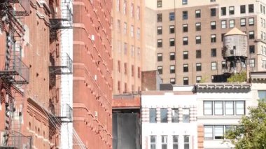 New York City Manhattan mimarisi. Şehir dışındaki konutlar. ABD 'de gayrimenkul. Kırmızı tuğla cephe. Yangın çıkışı, acil merdiven çıkışı. Çatıdaki su kulesi, çatıdaki tank..