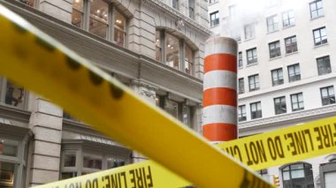 New York caddesinde buhar sızıntısı, turuncu buhar borusu yığını. Pipo dumanı. Con Edisons Buhar Operasyonları Sistemi, 5. Cadde, Manhattan Midtown. Sarı uyarı bandını geçmeyin.